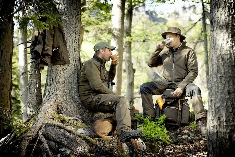 Jagd-Rucksack mit Fernglas, Axt, Thermosflasche und Zubehör im Wald – praktische Ausrüstung & Zubehör für Jäger und Outdoor-Abenteuer