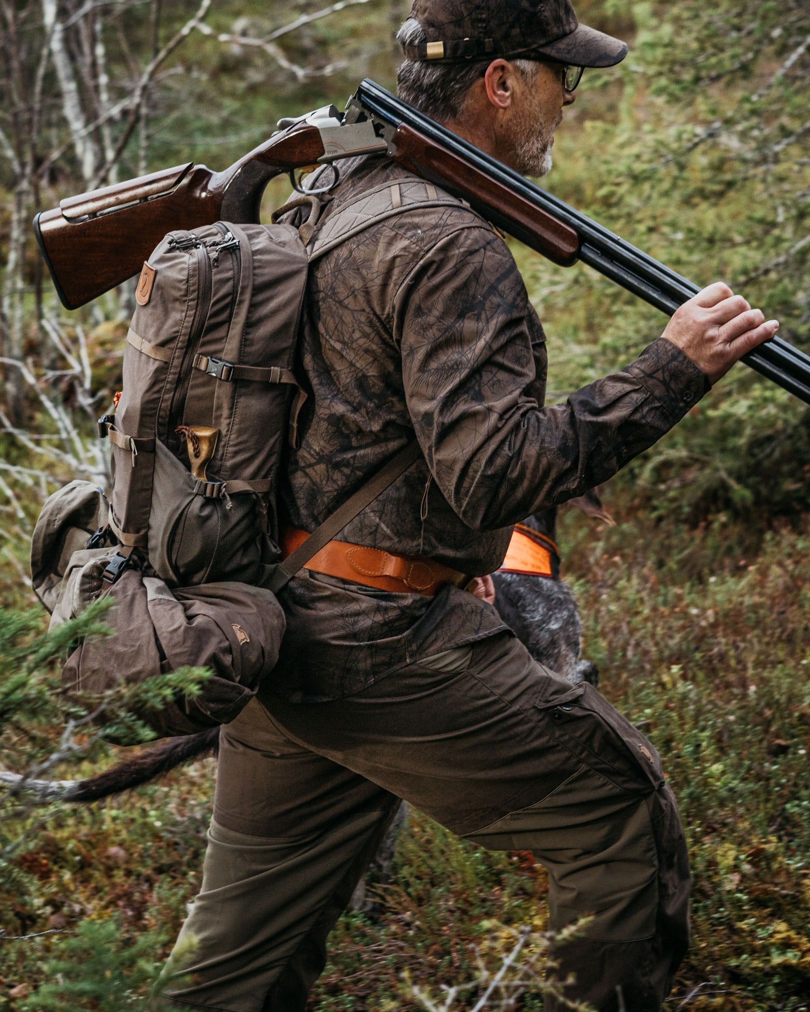Jäger mit orangefarbener Signal-Kappe und Funkgerät im Wald – hochwertige Kopfbedeckung und Jagdzubehör für Sicherheit und Sichtbarkeit