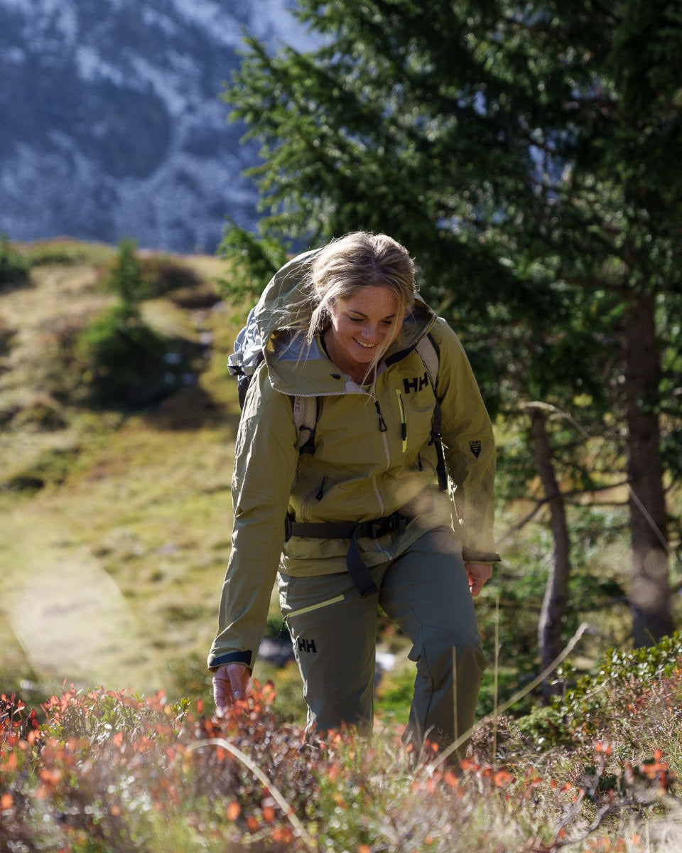 Frau in Outdoorbekleidung beim Wandern im Wald