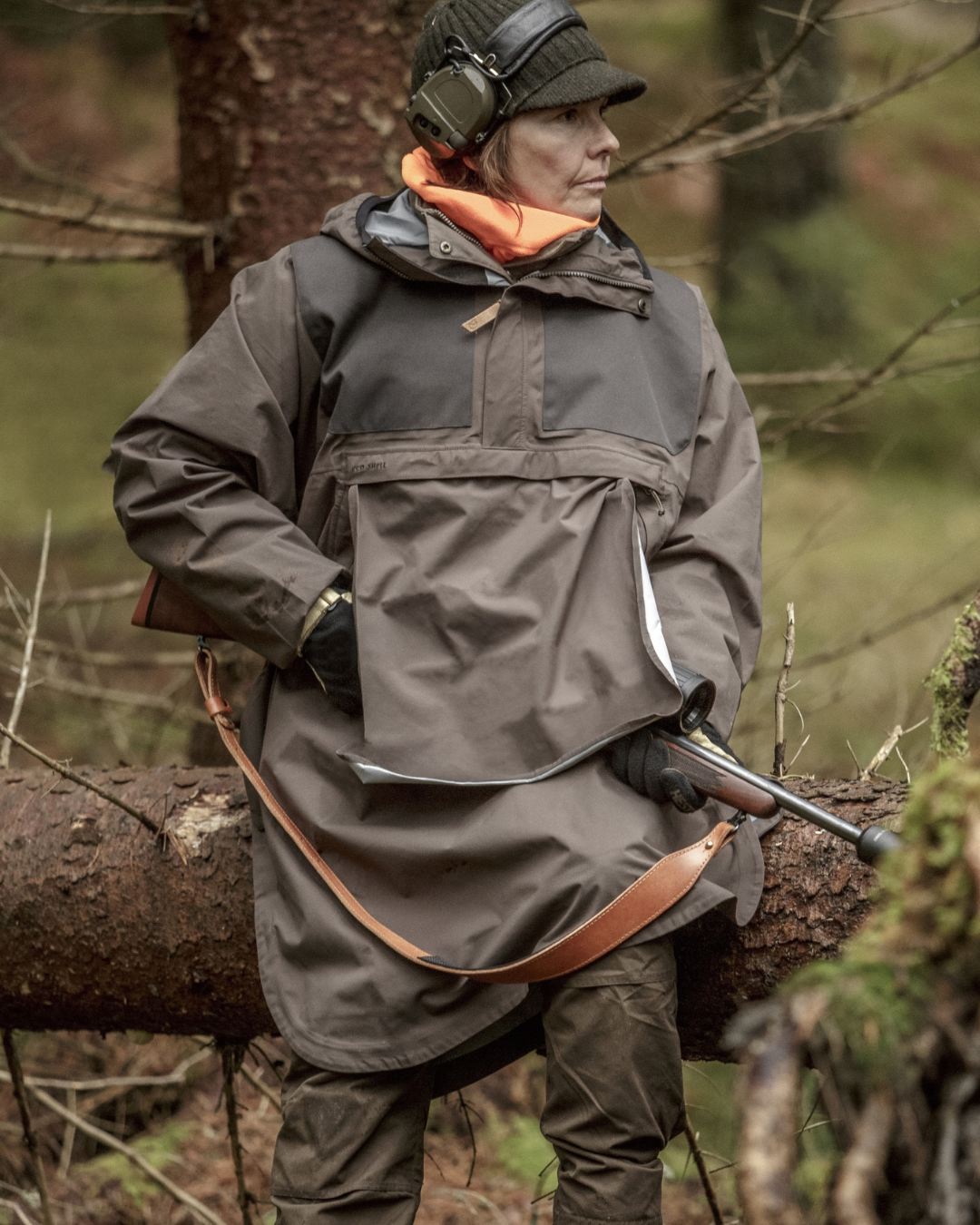 Jäger in wetterfester Regenkleidung im Wald