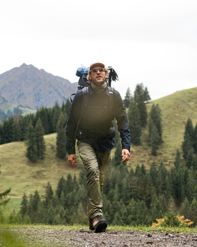 Mann mit Rucksack in der Natur – Outdoor-Bekleidung für Herren